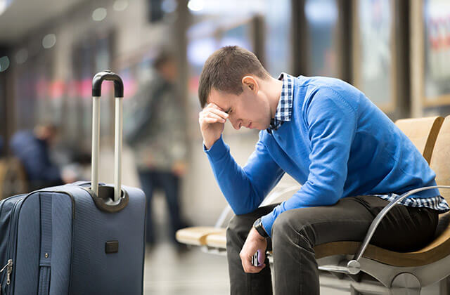 Foto de un viajero cansado con su maleta
